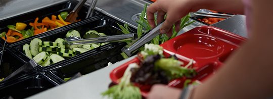 Student getting food from a salad bar